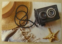 postcard of an old camera and sun hat